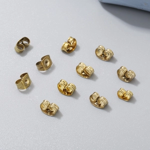 Vue de dessus de dix fermoirs papillon dorés à l'or 18 carats sur fond gris net