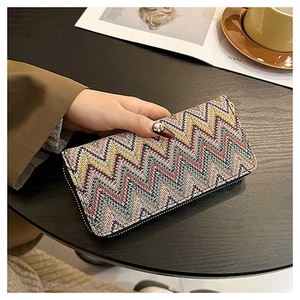 Detailed shot of long zipper wallet with colorful wave knit pattern on a cafe table
