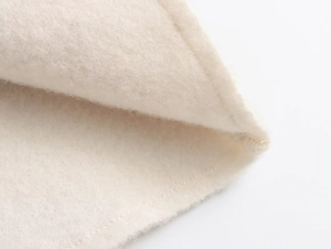 Macro shot of soft off-white fleece fabric texture and high-quality stitching detail