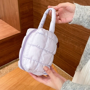 Detailed texture of lavender quilted cosmetic bag with soft fabric and square patterns