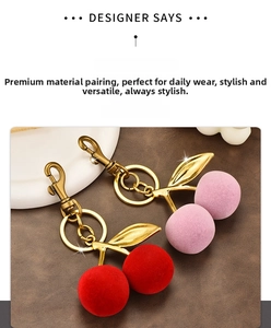 Detailed view of red and pink flocked cherry keychains with elegant gold leaf charms