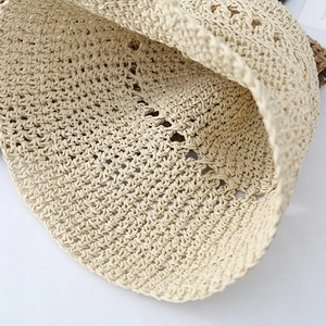 Close-up of the fine woven texture and breathable straw material of this beige sun hat