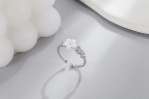 Macro detail of silver cherry blossom ring with pink cubic zirconia and shell petals