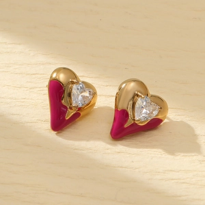 Macro detail of magenta heart earring with gold plating and heart-shaped zircon stone