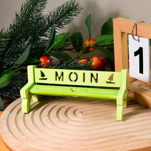 Miniature green wooden bench with MOIN engraving on a rustic wooden tray decoration
