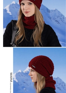 Deep red knitted beanie and neck warmer set shown against a snowy mountain backdrop