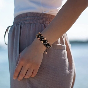 Gros plan d'un bracelet de yoga double couche ajustable avec des perles noires et grises