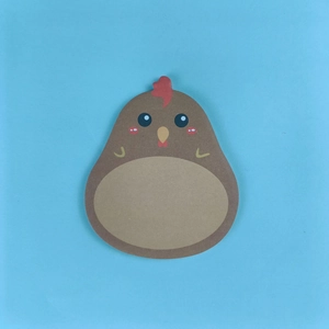 Close-up of cute brown rooster shaped sticky notes with red comb on blue background