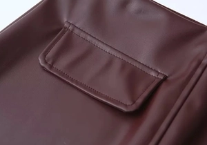 Detailaufnahme der quadratischen Tasche und Naht an der kaffeebraunen PU-Lederjacke