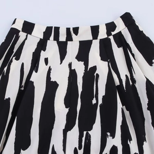 Detalle de falda midi de talle alto con estampado abstracto en blanco y negro y pliegues