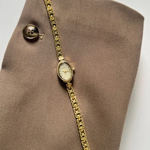 Montre vintage dorée à cadran ovale pour femme avec bracelet chaîne en métal gaufré