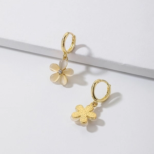 Macro detail of gold flower earrings featuring faux cat eye stones and cubic zirconia