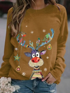 Detail of loose fit mustard yellow sweatshirt with festive Christmas reindeer print