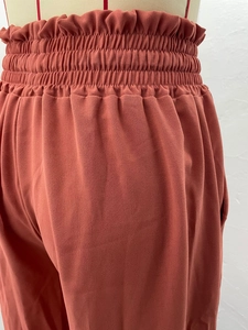 Détail de la taille haute élastique sur le pantalon large rouge rouille pour femme