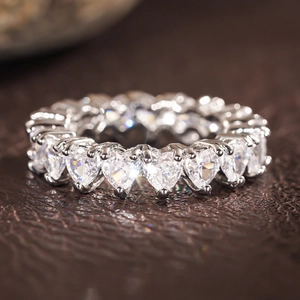 Detailed view of silver eternity ring with heart-cut crystals in a claw setting