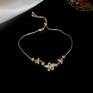 Detail of adjustable gold flower bracelet with white stones and sparkling crystals