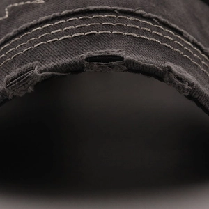 Close-up of distressed denim baseball cap with vintage wash and triple-stitched edge