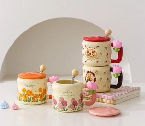Detail of four ceramic tulip mugs with lids and spoons in different colors