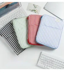Top view of four checkered laptop sleeves in black, green, red, and blue colors