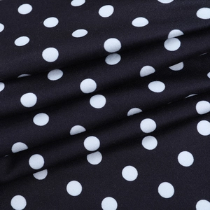 Detailed macro view of black fabric with white polka dots and high-quality knit texture