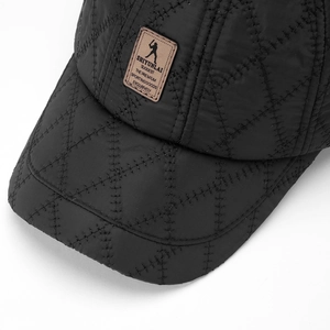 Close-up of black quilted baseball cap with premium brown leather logo patch detailing