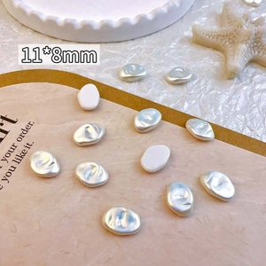 Macro shot of 11x8mm baroque pearl nail charms on a vintage display card