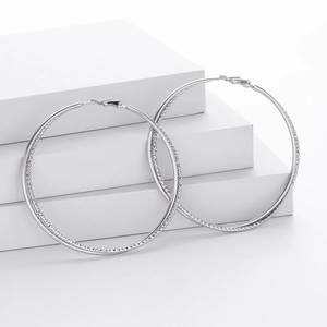 Close-up of S925 sterling silver hoop earrings with diamond-cut textured engraving