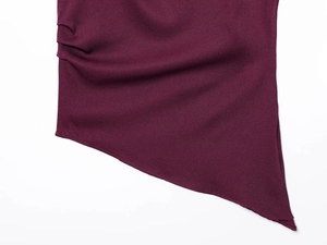 Detail view of burgundy ruched top with asymmetric cut and shoulder pad texture