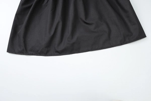 Close-up of black pleated hem and fine stitching details on the sweet style dress