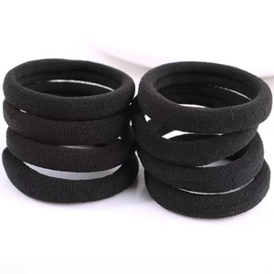 Macro shot showing high-elasticity black seamless hair ties with thick knitted texture