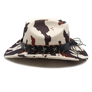 Detail of cow print cowboy hat featuring leather band with star rivets and tassel