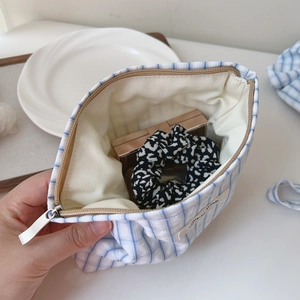 Detail of blue checkered pouch showing zipper closure and spacious inner storage space