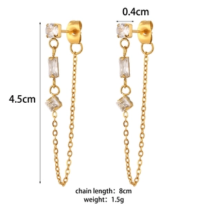 Golden tassel earrings with zircon chains and geometric pendants on white background