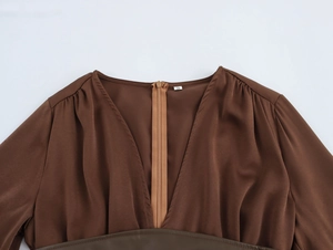 Detail of the brown silk V-neck top showing the S size label and leather waist belt