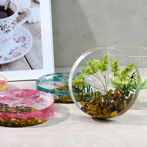 Artistic detail of round resin coasters with real dried flowers and tiger eye stones