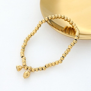 Detailansicht eines goldenen Perlenarmbands mit zwei Lotusknospen-Anhängern auf weißem Grund