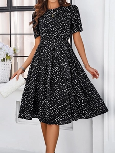 Détail de la taille nouée et motif à pois blancs sur robe midi noire à manches courtes
