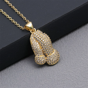 Macro view of gold plated phallic pendant featuring pavé set clear cubic zirconia stones