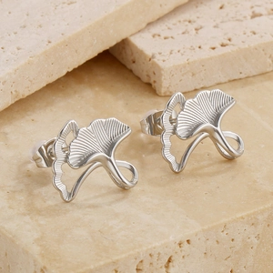 Close-up of silver ginkgo leaf stud earrings with detailed brushed metal texture
