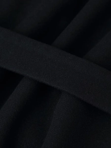 Gros plan sur la texture du tissu en laine mélangée noire d'un manteau long élégant