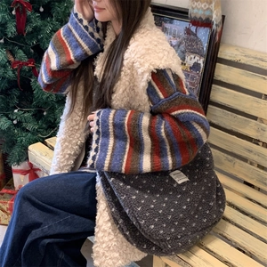 Detailed view of the plush grey polka dot crossbody bag in a cozy winter setting