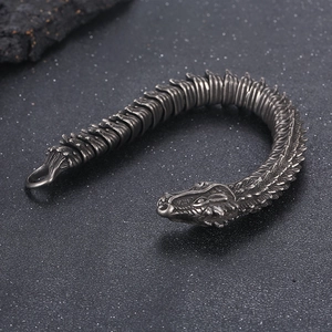 Dettaglio ravvicinato del bracciale drago d'argento retrò con squame su sfondo nero opaco