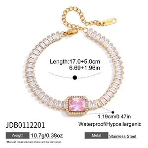 Détail d'un bracelet en acier inoxydable doré avec zircons roses et fermoir mousqueton