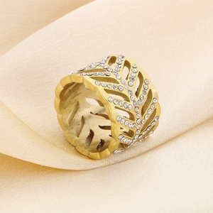 Macro shot of gold-plated hollow leaf ring with pavé rhinestones on silk fabric