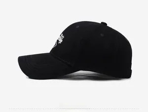 Side view of black cotton baseball cap featuring white letter embroidery on the side