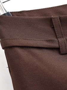 Dettaglio ravvicinato del tessuto twill marrone e delle cuciture in vita dei pantaloni