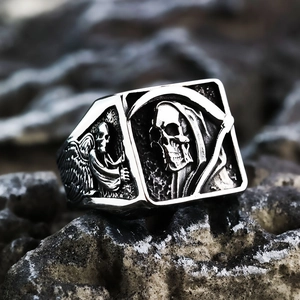 Macro shot of punk grim reaper skull ring with gothic wings on rustic stone surface