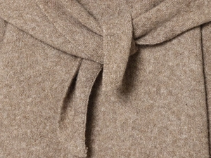 Detailed close-up of premium camel knit fabric with soft wool texture and waist tie