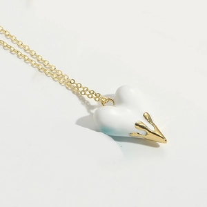 Macro detail of a classic love heart pendant necklace with gold drip metal design