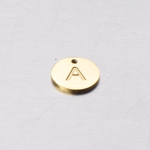 Macro shot of 12mm gold mirror-finish stainless steel round pendant with engraved letter A
